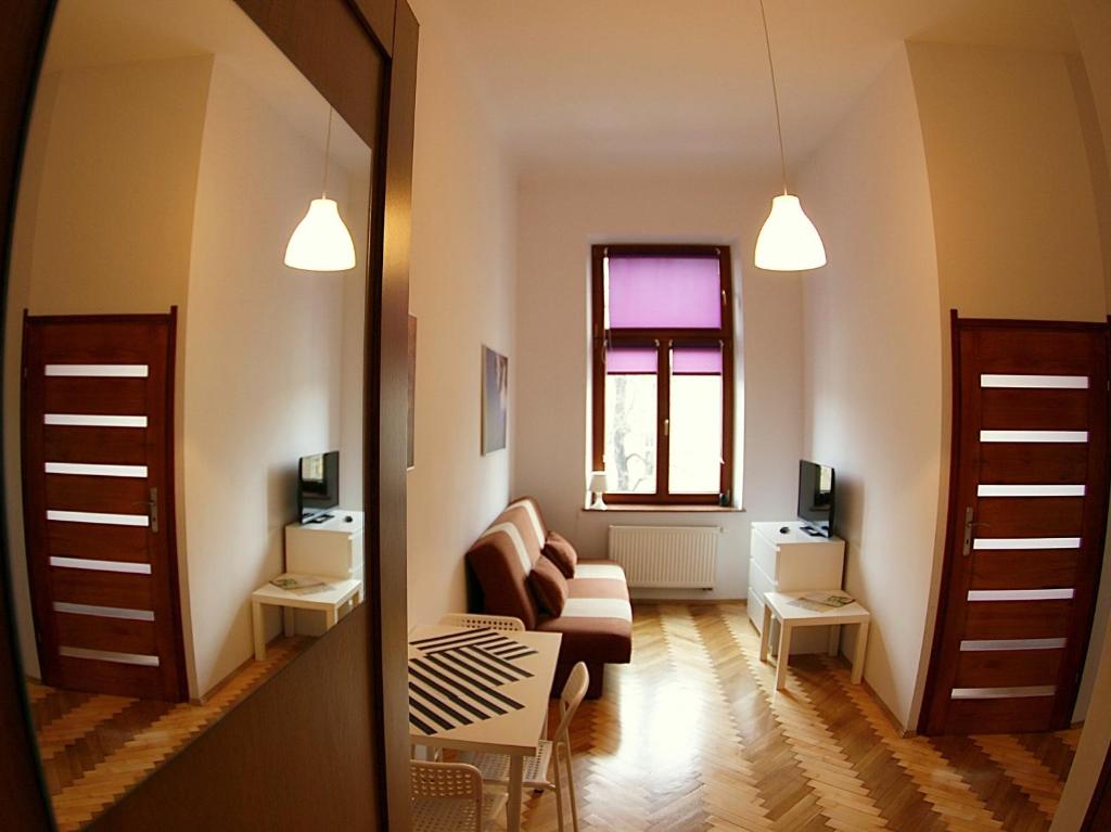 ein Wohnzimmer mit einem Sofa und einem Fenster in der Unterkunft VisitKrak in Krakau
