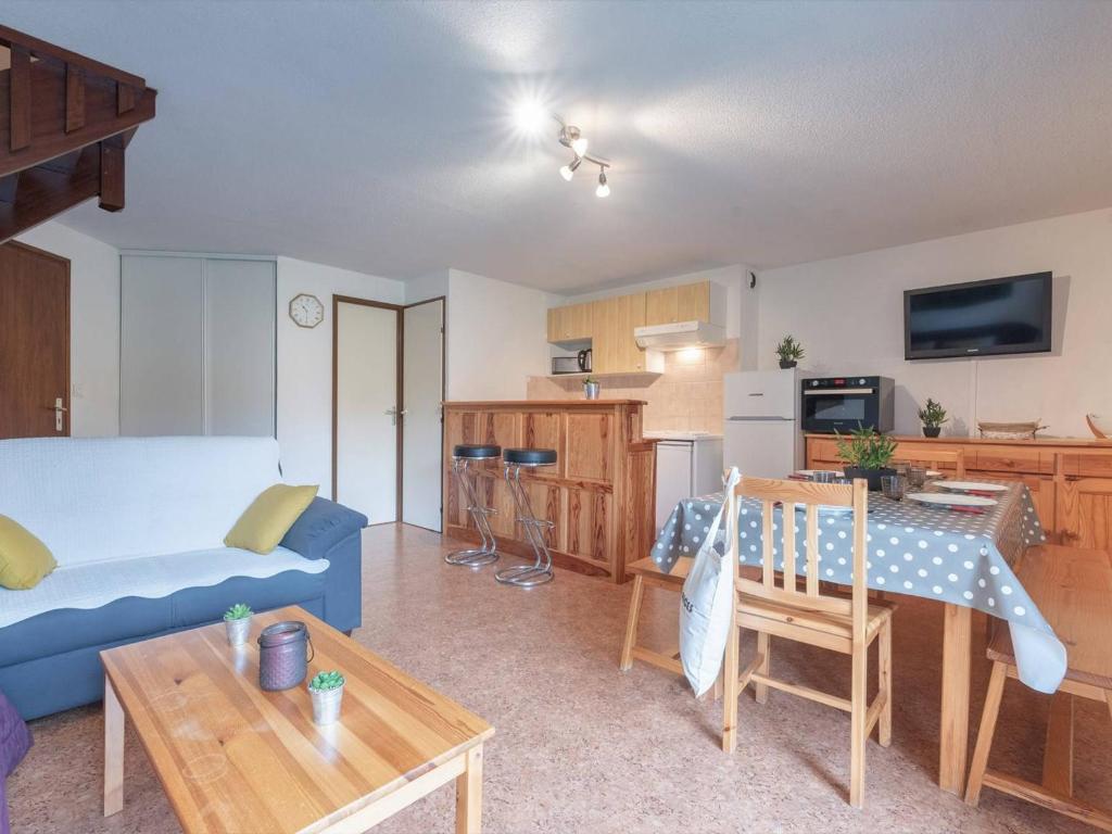 un salon avec un canapé bleu et une cuisine dans l'établissement Appartement Triplex à Saint-Lary, 4 chambres, 9 pers, balcon, parking, WiFi optionnel - FR-1-296-287, à Saint-Lary-Soulan