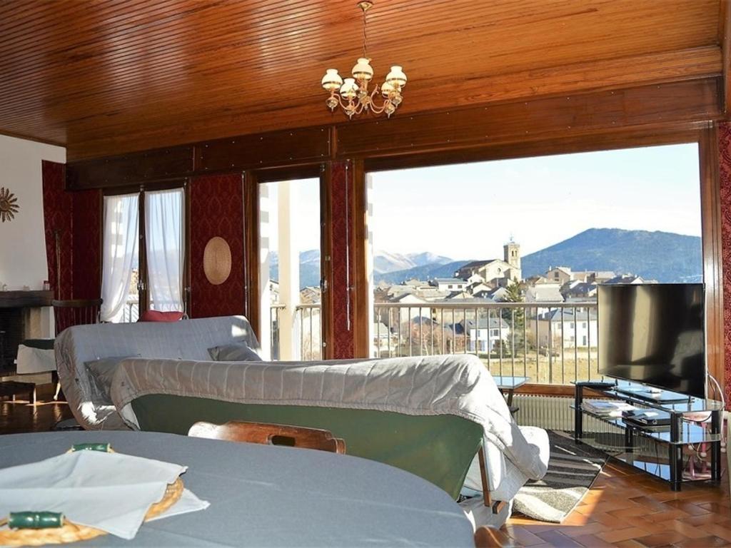 une chambre avec deux lits et un balcon avec vue dans l'établissement Les Angles : Apt 6 pers, 2 ch, balcon, proche pistes - FR-1-593-25, aux Angles