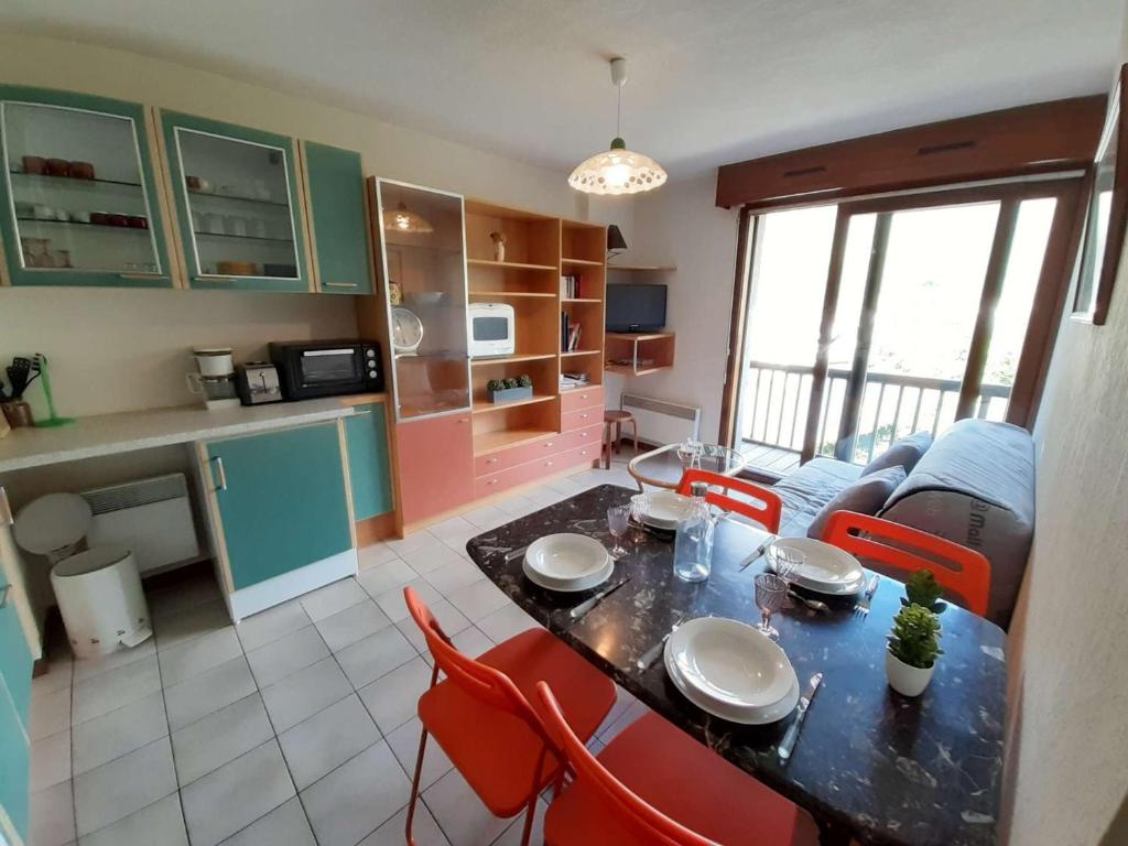 eine Küche und ein Wohnzimmer mit einem Tisch und Stühlen in der Unterkunft Appartement Saint-Lary-Soulan, 2 pièces, 4 personnes - FR-1-457-160 in Saint-Lary-Soulan