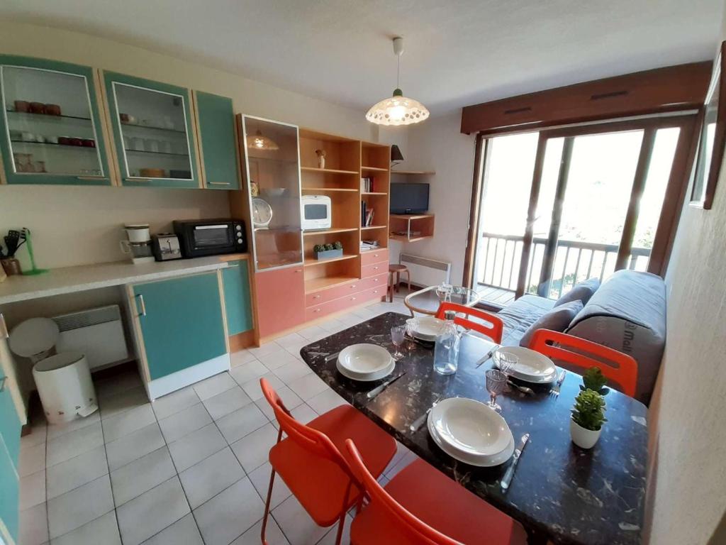 una cucina e un soggiorno con tavolo e sedie di Saint-Lary-Soulan : T2 4 pers, vue ouest, balcon, ascenseur, proche Pla d'Adet - FR-1-457-160 a Saint-Lary-Soulan