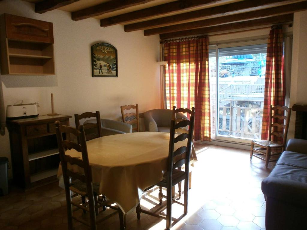 een eetkamer met een tafel en stoelen en een raam bij Appartement Saint-Lary-Soulan, 5 pièces, 8 personnes - FR-1-457-169 in Saint-Lary-Soulan
