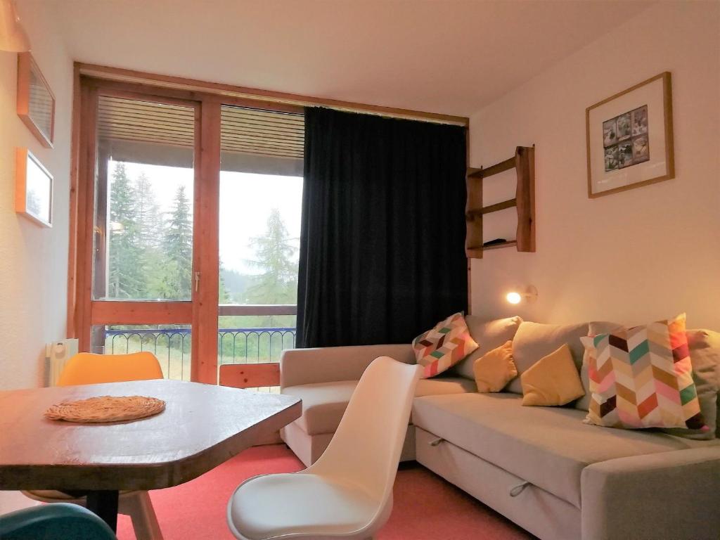 ein Wohnzimmer mit einem Sofa und einem Tisch in der Unterkunft Studio Les Arcs 1800, 1 pièce, 4 personnes - FR-1-411-642 in Arc 1800