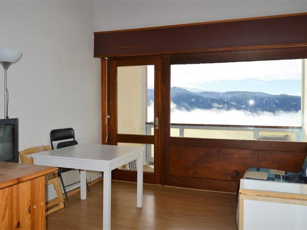 - un salon avec une table blanche et une fenêtre dans l'établissement Studio mezzanine avec balcon et parking, plein sud, proche des pistes, 4 pers - FR-1-580-33, à Font-Romeu-Odeillo-Via