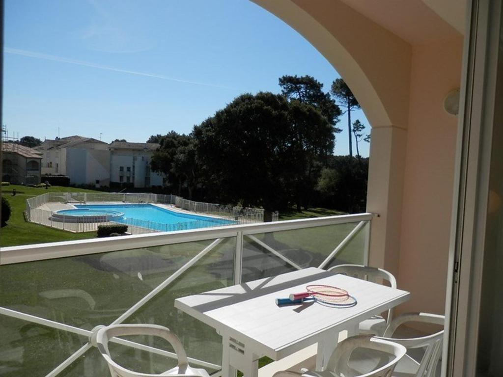 d'un balcon avec une table et des chaises, ainsi que d'une piscine. dans l'établissement Appartement T2 avec piscine, balcon, parking privé - Moliets-et-Maa - FR-1-379-113, à Moliets-et-Maa