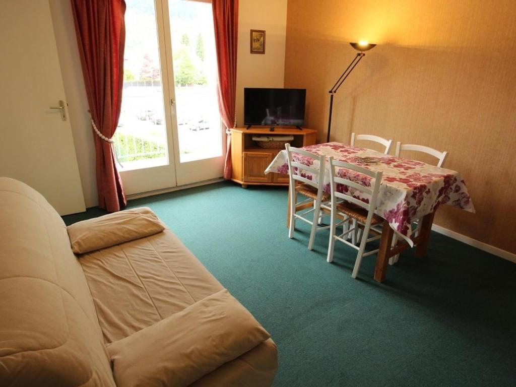 ein Wohnzimmer mit einem Tisch, Stühlen und einem Sofa in der Unterkunft Appartement Bagnères-de-Luchon, 2 pièces, 4 personnes - FR-1-313-185 in Luchon