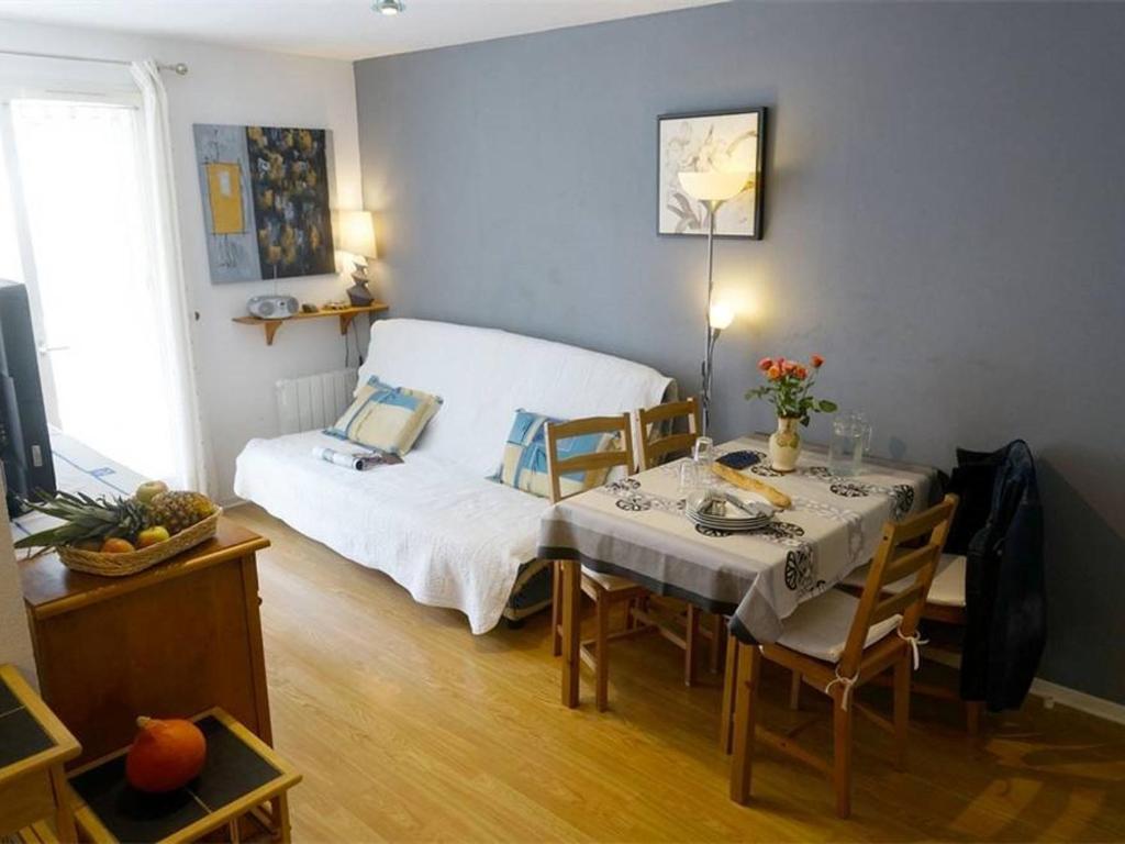 a room with a table and a bed in a room at T2 Calme - Balcon - Parking - Animaux admis - FR-1-313-187 in Luchon