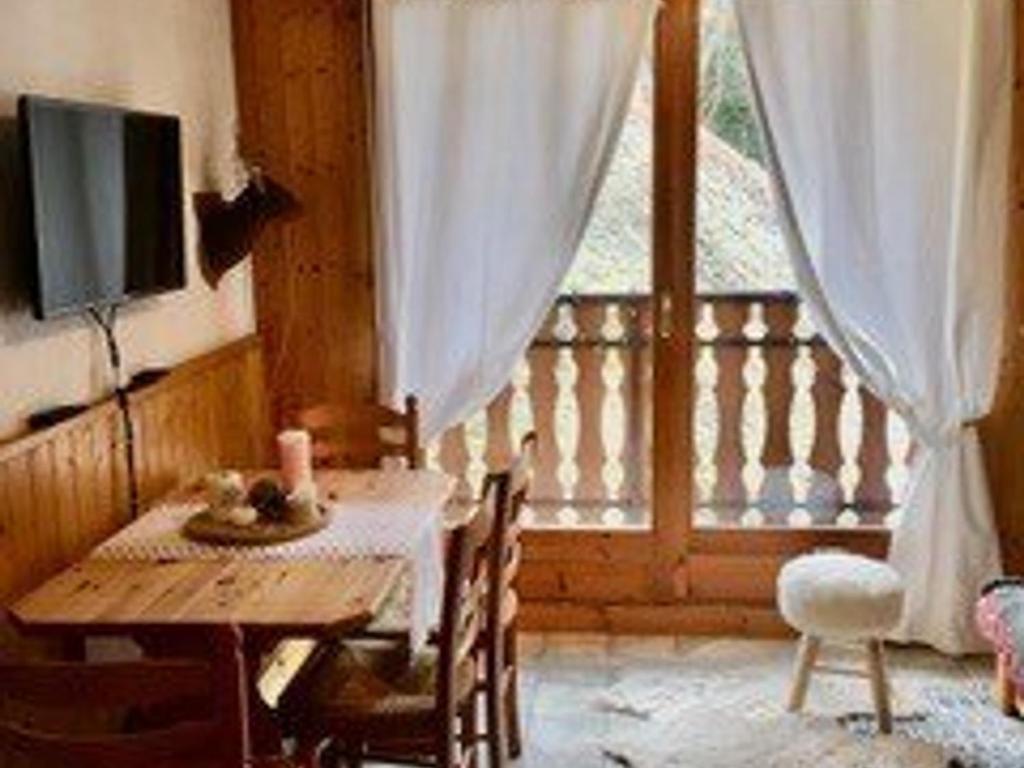 une salle à manger avec une table et une télévision dans l'établissement Location 2 pièces au pied des pistes avec balcon, Saint-Jean-d'Aulps - FR-1-573-30, à Saint-Jean-dʼAulps
