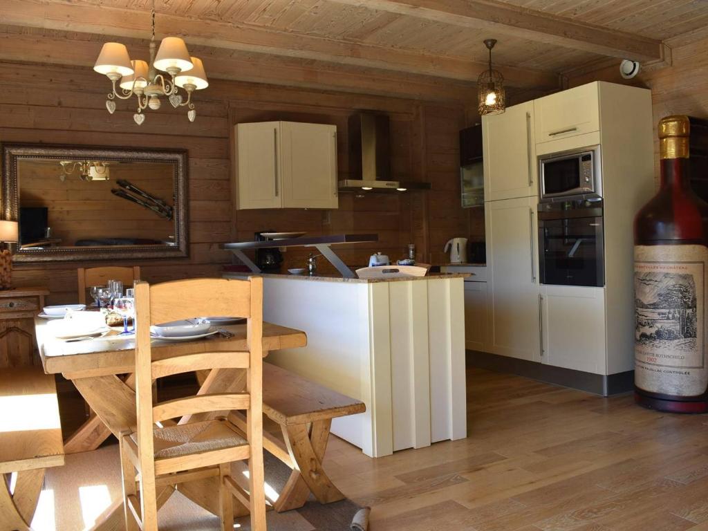 una cocina con armarios blancos y una mesa con una botella de vino en Appartement Méribel, 4 pièces, 6 personnes - FR-1-180-455 en Les Allues
