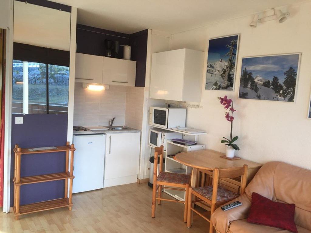 une petite cuisine avec une table et un canapé ainsi qu'une chambre dans l'établissement Studio 4 pers, accès direct pistes, parking gratuit - FR-1-602-50, à Arette