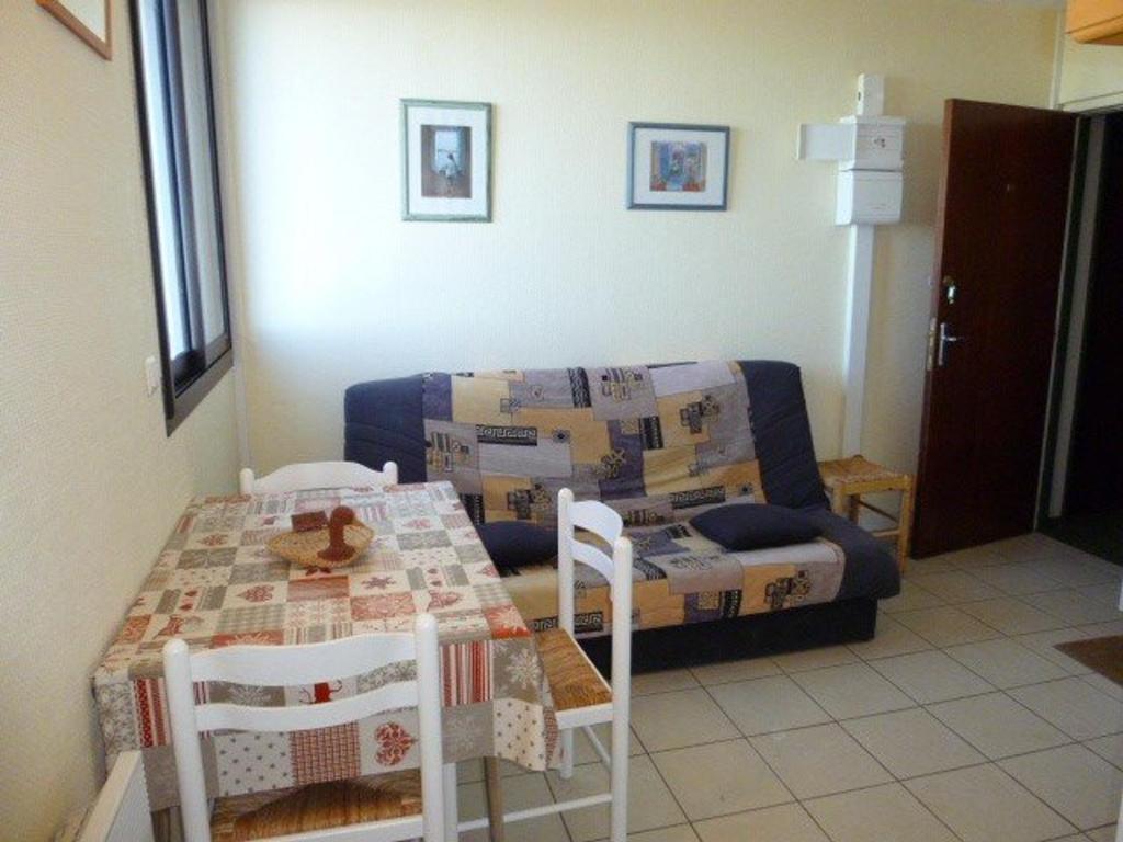 a living room with a table and a couch with boxes at Appartement Arette, 2 pièces, 6 personnes - FR-1-602-53 in Arette