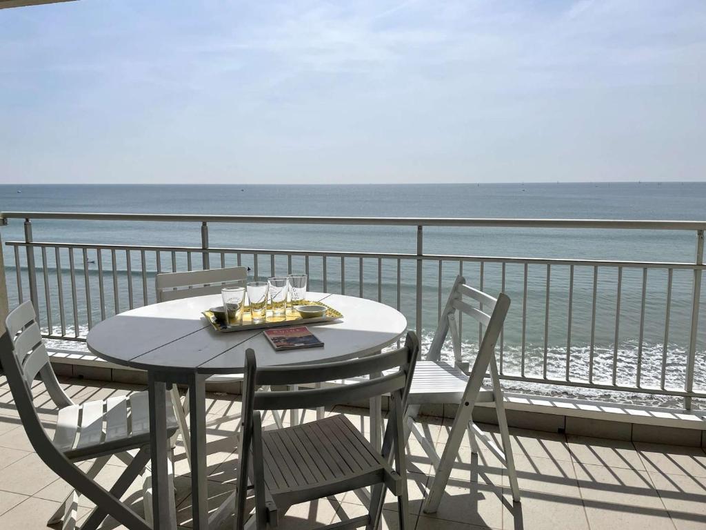 a table and chairs on a balcony overlooking the ocean at Appartement spacieux 1er étage avec balcon, vue mer, double garage à Saint-Gilles-Croix-de-Vie - FR-1-224-775 in Saint-Gilles-Croix-de-Vie