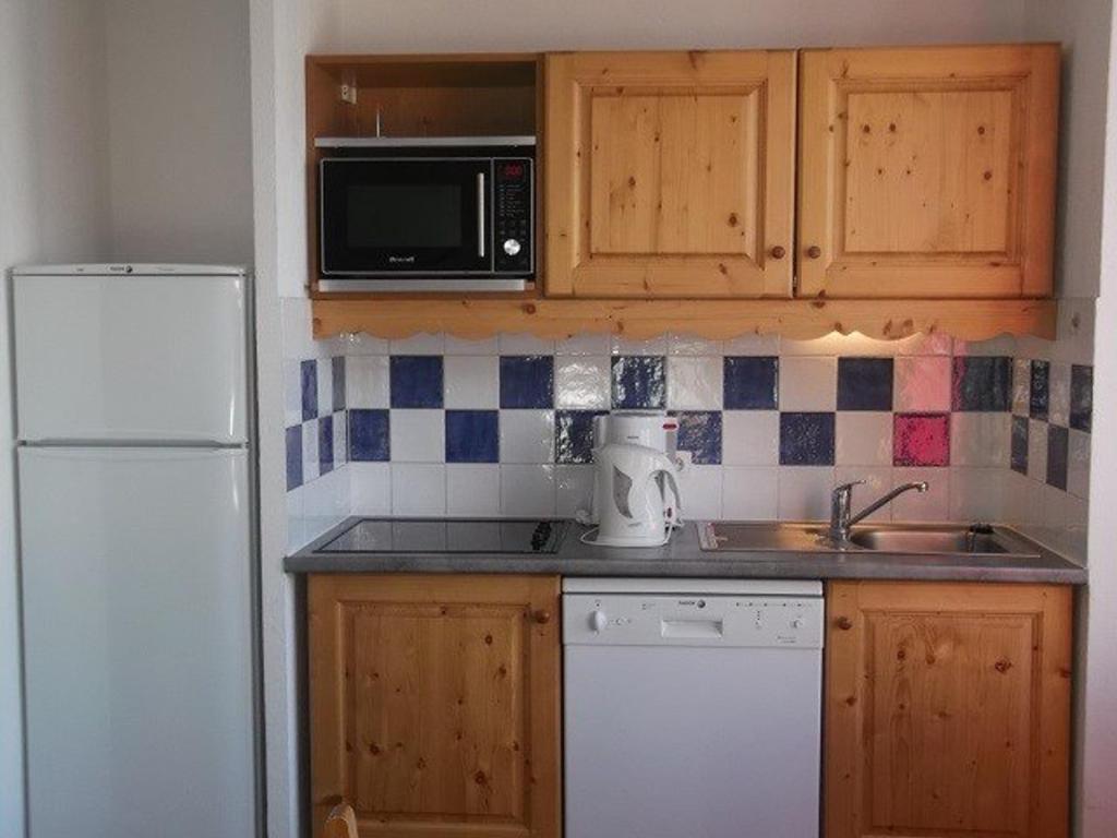 eine Küche mit einem weißen Kühlschrank und einer Spüle in der Unterkunft Appartement Orcières Merlette, 3 pièces, 6 personnes - FR-1-262-167 in Orcières
