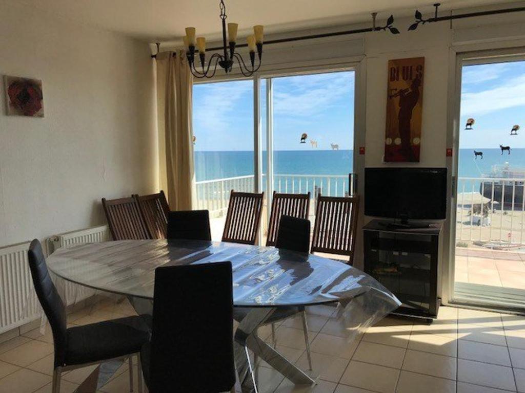 a dining room with a table and a view of the ocean at Appartement Le Barcarès, 3 pièces, 6 personnes - FR-1-81-497 in Le Barcarès