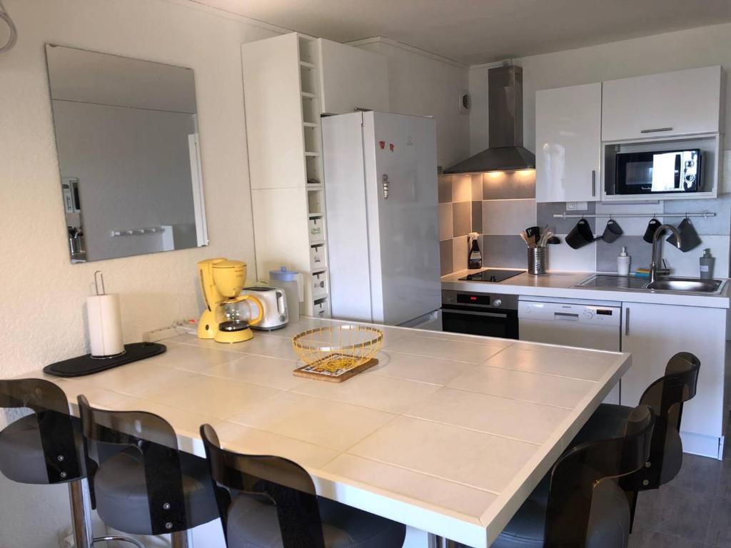 une cuisine avec une table et des chaises dans une cuisine dans l'établissement Appartement 2 pièces climatisé, parking privé, proche plage - FR-1-81-535, à Port-Leucate