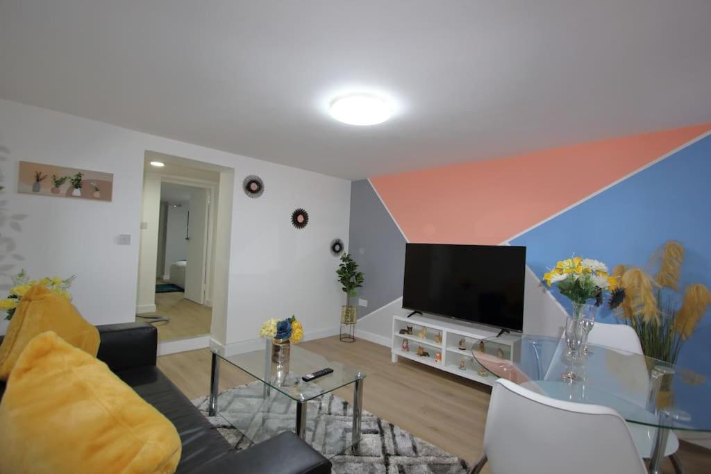 a living room with a couch and a tv at Oasis, Central Self Contained Flat by CozyNest in Reading