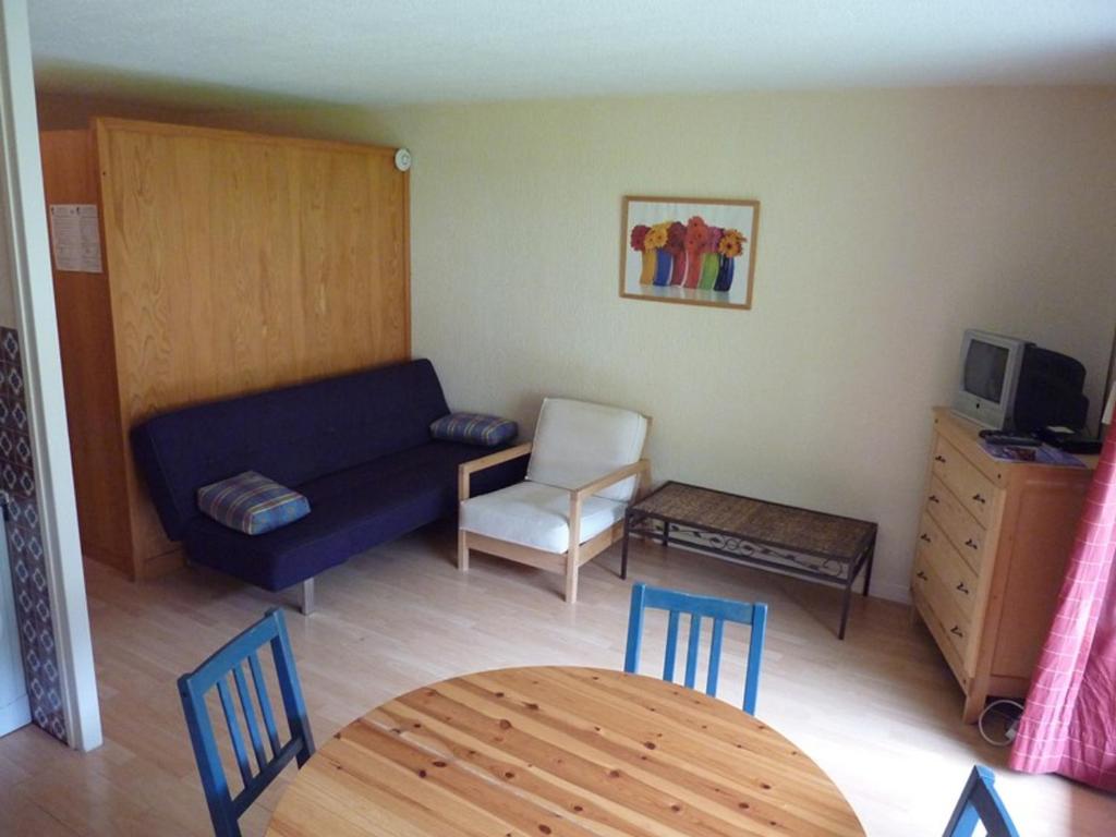 ein Wohnzimmer mit einem Sofa, einem Tisch und Stühlen in der Unterkunft Appartement Saint-Jean-d'Aulps, 1 pièce, 4 personnes - FR-1-573-38 in Saint-Jean-dʼAulps
