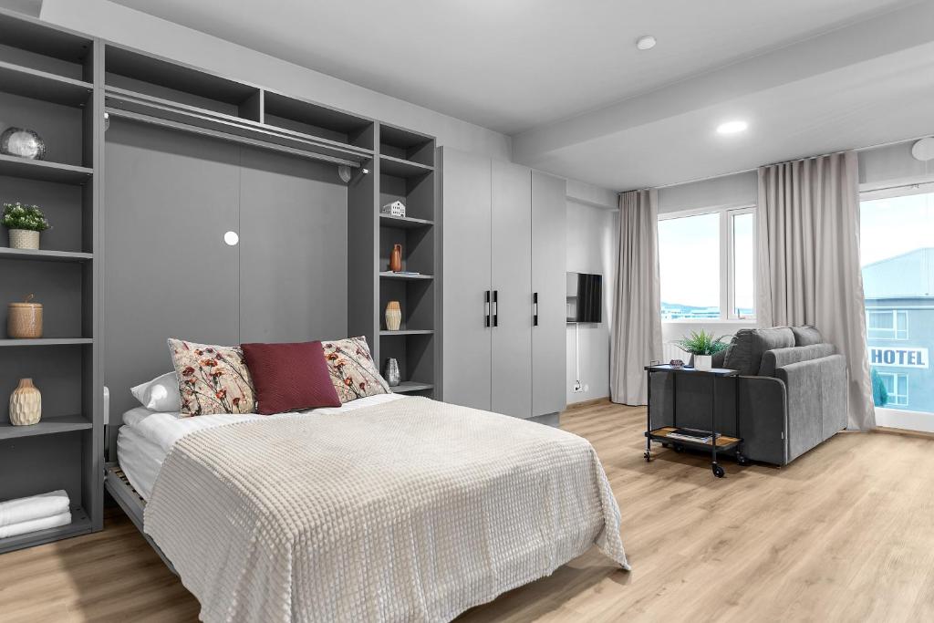een slaapkamer met een bed, een bank en een stoel bij B20 Apartments in Reykjavík