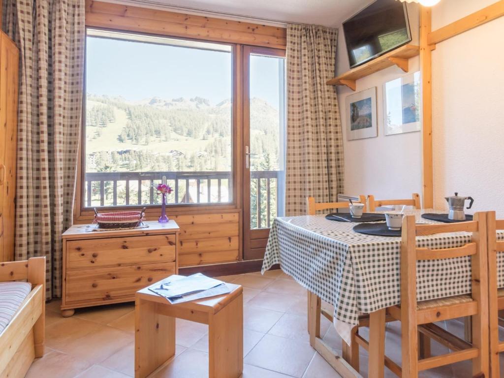 d'un salon avec une table et un balcon. dans l'établissement Appartement Montgenèvre, 1 pièce, 3 personnes - FR-1-330D-117, à Montgenèvre