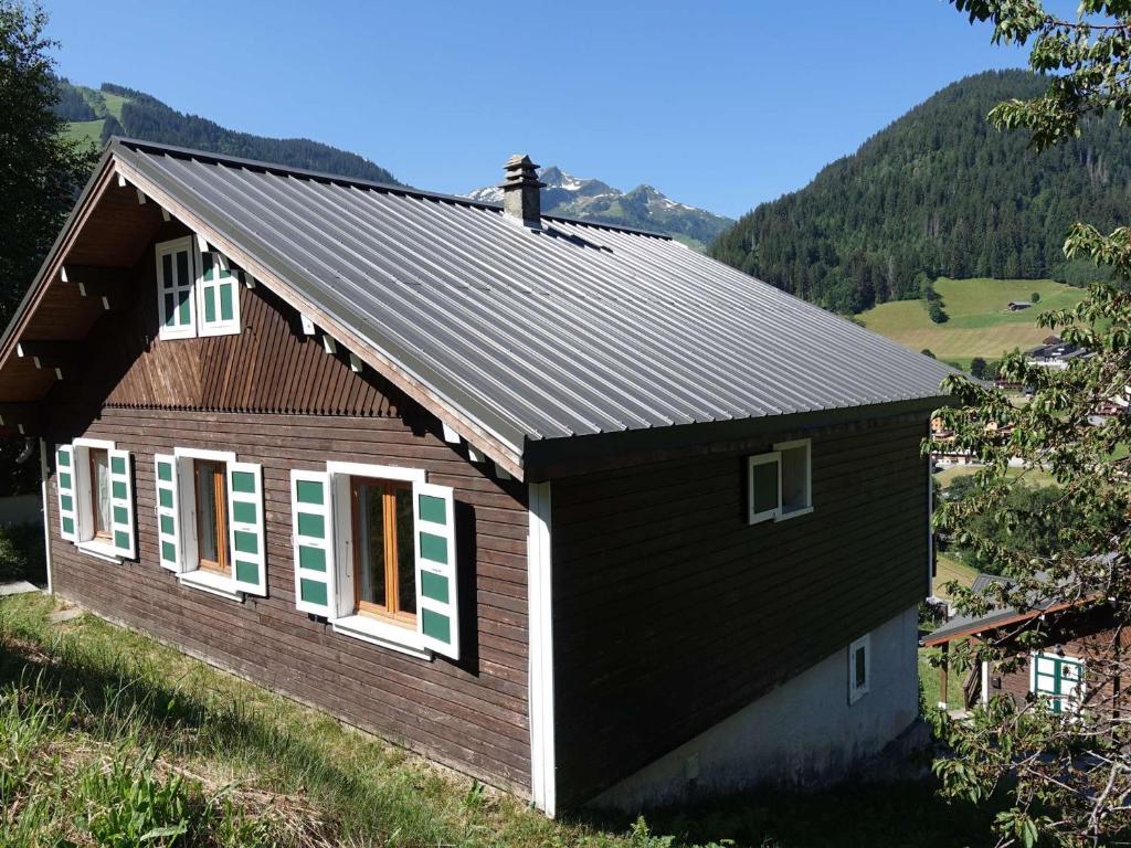 une petite maison sur une colline avec des montagnes en arrière-plan dans l'établissement Chalet Arêches-Beaufort, 5 pièces, 6 personnes - FR-1-342-225, à Beaufort