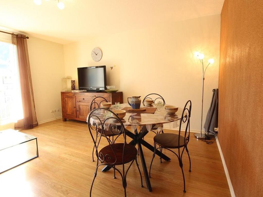 a dining room with a table and chairs and a tv at Appartement 2 pièces cabine avec balcon, parking, animaux admis, Wi-Fi - FR-1-313-195 in Luchon