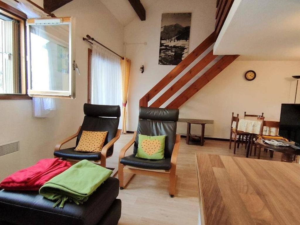 a living room with two chairs and a staircase at Appartement Cauterets, 3 pièces, 6 personnes - FR-1-234-263 in Cauterets