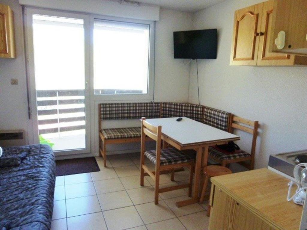 una pequeña cocina con mesa y sofá en Studio Arette, 1 pièce, 4 personnes - FR-1-602-42, en Arette