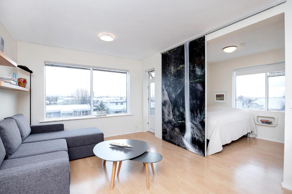 een woonkamer met een bank en een tafel bij Overlooking the city, bright & cozy - Free Parking (A2) in Reykjavík