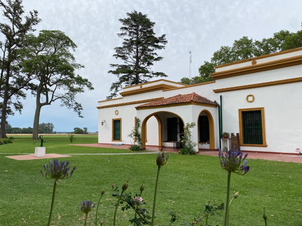 un gran edificio blanco con un patio de césped en Estancia Santa Margarita 1873 en Junín