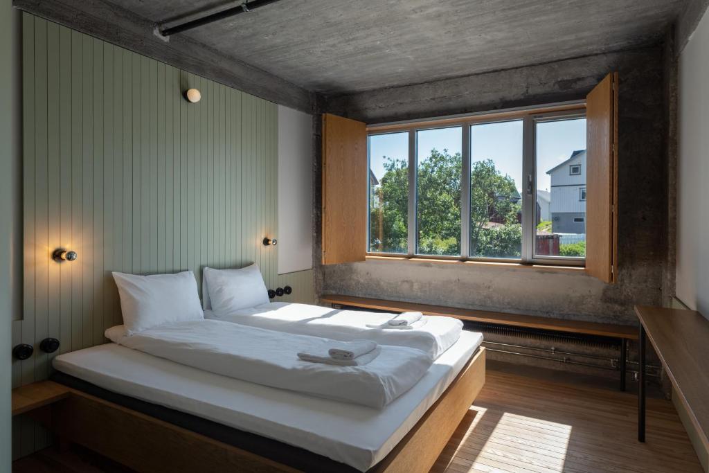 a large bed in a room with a window at Trevarefabrikken in Henningsvær