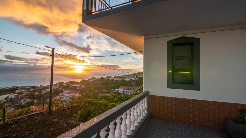 uma varanda com vista para o mar ao pôr-do-sol em Madeira Inn Refugio do Sol na Calheta