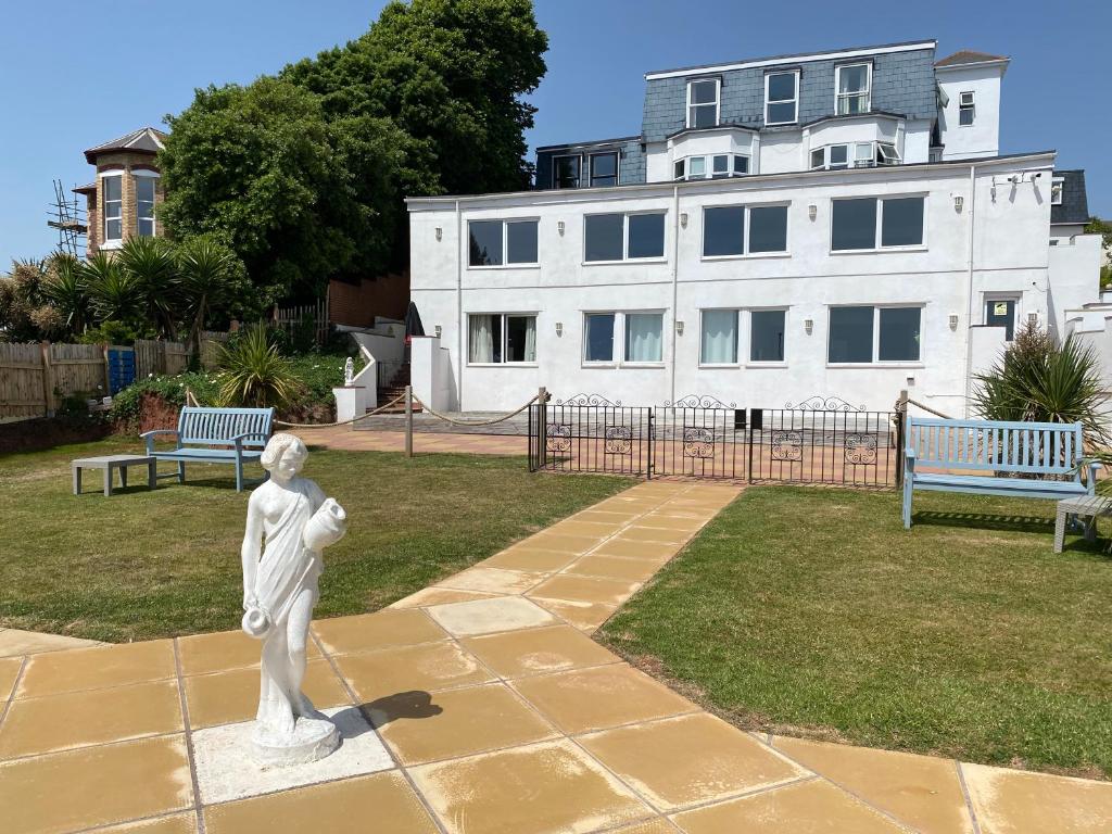 a statue in front of a building with two benches at Waters Edge Hotel in Torquay