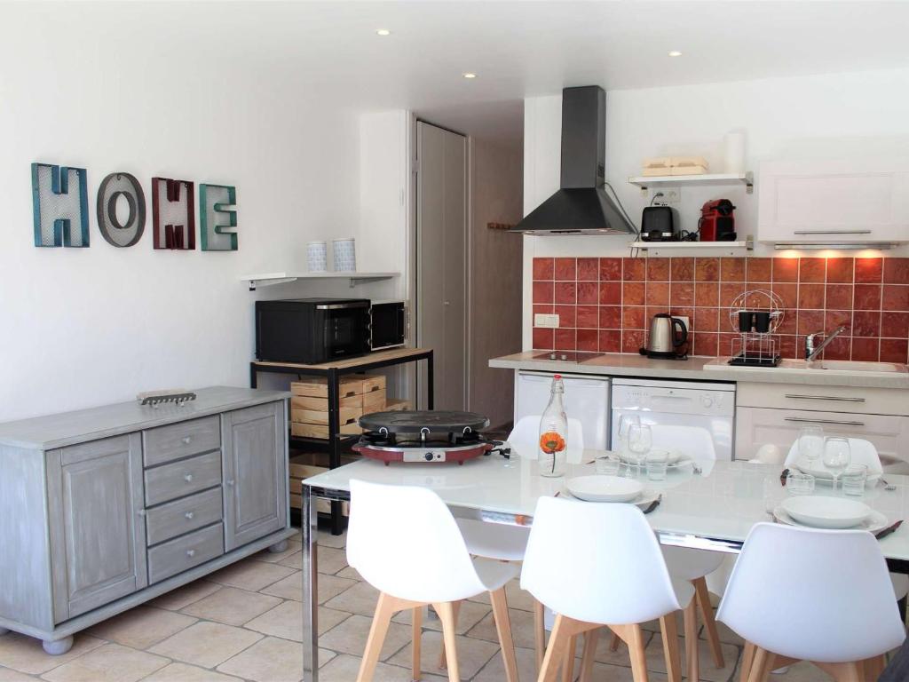 une cuisine avec une table et des chaises blanches dans l'établissement Studio cosy à Vars Les Claux, 4 couchages, balcon sud, au pied des pistes et proche commerces - FR-1-330B-191, à Vars