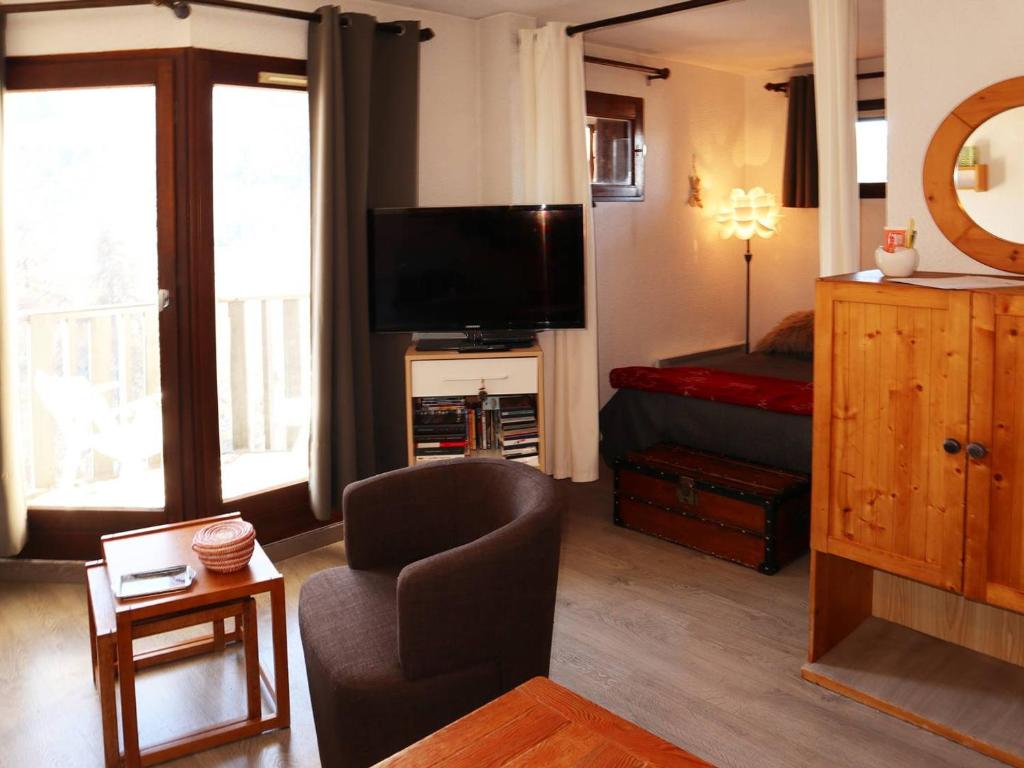 - un salon avec une télévision, une chaise et un lit dans l'établissement Grand studio rénové, skis aux pieds, idéal famille, 6 pers, Les Orres - FR-1-322-469, aux Orres