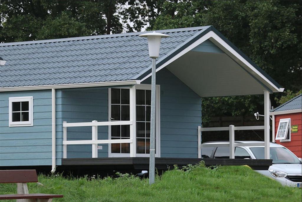 a blue house with a porch and a white railing at Ferienpark Plötzky in Schönebeck