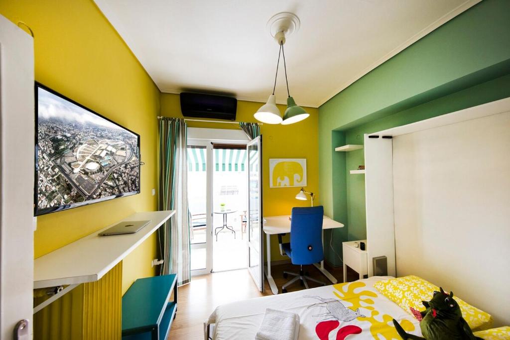 una camera da letto con pareti gialle e verdi e una scrivania di Startupper's Pad in real Athenian neighbourhood ad Atene