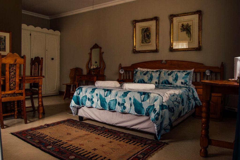 Farm stay at Fennel Cottage on Haldon Estate في بلومفونتين: غرفة نوم بسرير وطاولة ومرآة