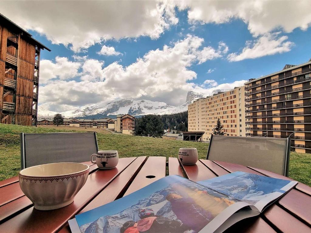 a wooden table with a book and a bowl on it at Appartement Le Dévoluy, 2 pièces, 6 personnes - FR-1-525-195 in Le Dévoluy