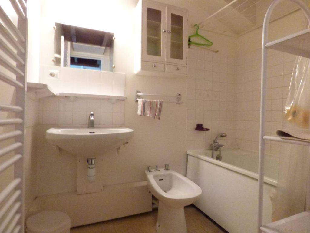 uma casa de banho branca com um lavatório e um WC em Appartement Arette, 2 pièces, 6 personnes - FR-1-602-83 em Arette
