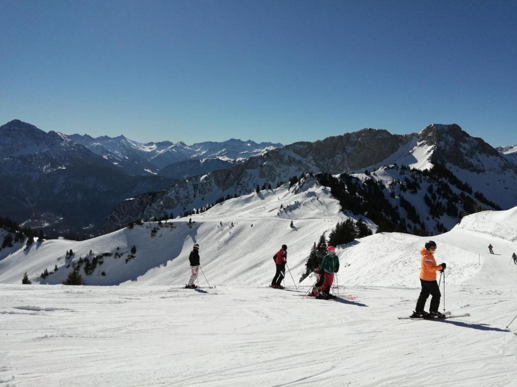 un gruppo di persone che sciano giù da una montagna innevata di Sand 4 a Stanzach