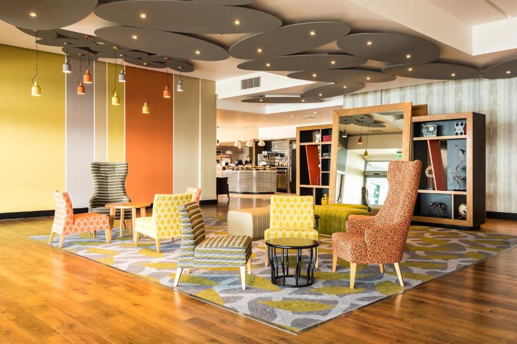 a lobby with colorful chairs and a table at Holiday Inn Brighton Seafront by IHG in Brighton & Hove