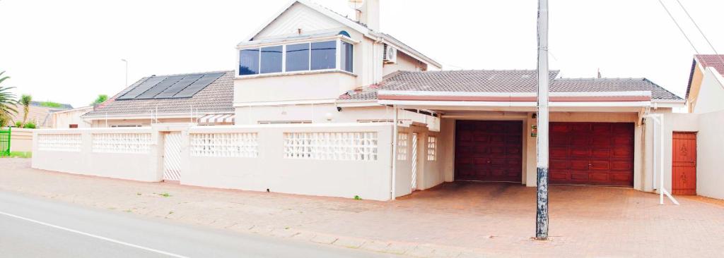 una casa blanca con una valla delante en KINGFISHER PLACE en Lenasia