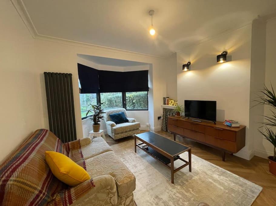 ein Wohnzimmer mit einem Sofa und einem TV in der Unterkunft Cheerful 2 bed house on Causeway Coastal Route with parking in Whiteabbey