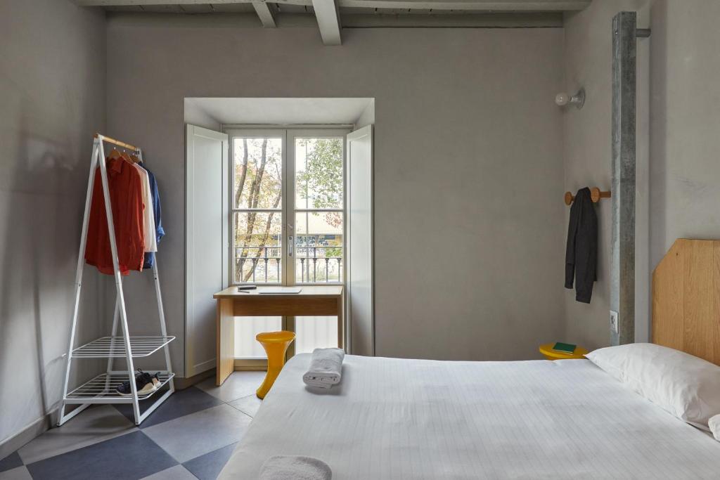 a bedroom with a bed and a window and a desk at Combo Milano in Milan