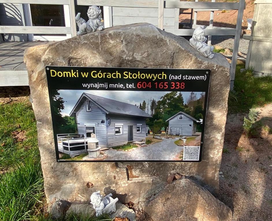 un cartel en una roca con una foto de una casa en Domki w Górach Stołowych, en Kudowa-Zdrój