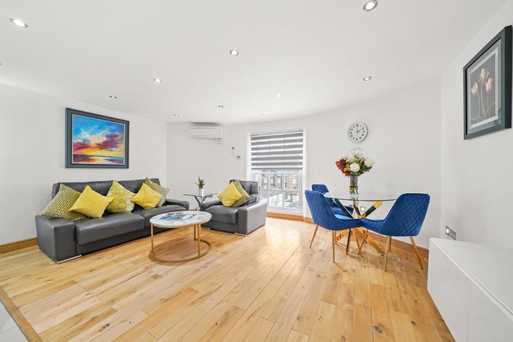 ein Wohnzimmer mit einem Sofa und einem Tisch in der Unterkunft Baker Street Suite in London