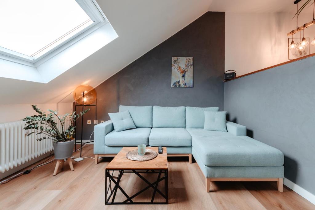 sala de estar con sofá azul y mesa en CozyStay - Gemütliche Wohnung im Oberharz, en Sankt Andreasberg