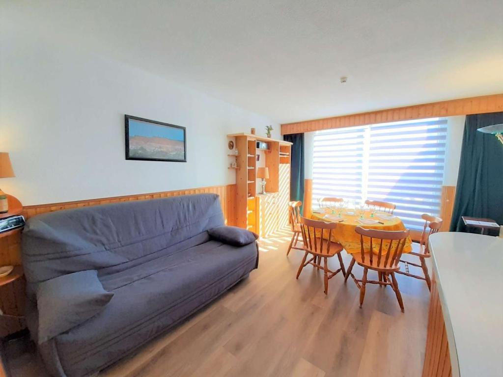 un salon avec un canapé et une table avec des chaises dans l'établissement Studio cabine 6 pers à Piau-Engaly avec balcon et vue sur pistes - FR-1-457-302, à Aragnouet