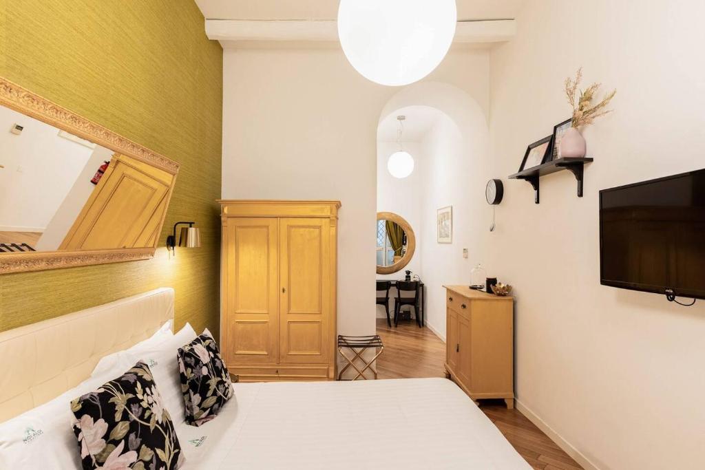 a bedroom with a bed and a flat screen tv at Vittoria Charme in Rome