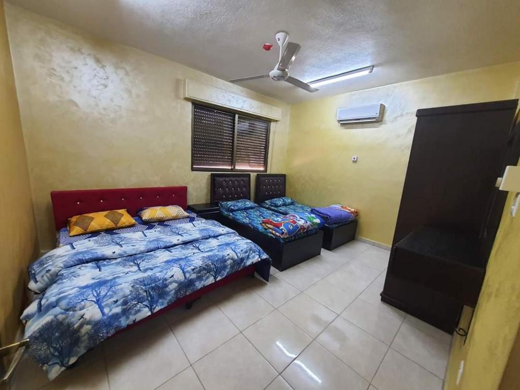 una camera da letto con due letti e un ventilatore a soffitto di العاصم للشقق الفندقية ALASEM HOTEL APARTMENTS ad Aqaba